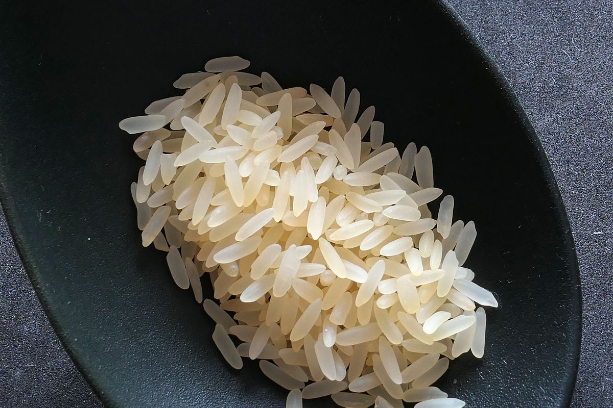 Das wohl bekannteste Beispiel einer gentechnisch veränderten Nutzpflanze ist der „Golden Rice“, der mit β (Beta)-Carotin angereichert wurde. Durch den Inhaltsstoff haben diese Reiskörner - anders als der „normale“ hier abgebildete weiße Reis - eine charakteristisch orange-gelbe Farbe, was dem Reis seinen Namen einbrachte.