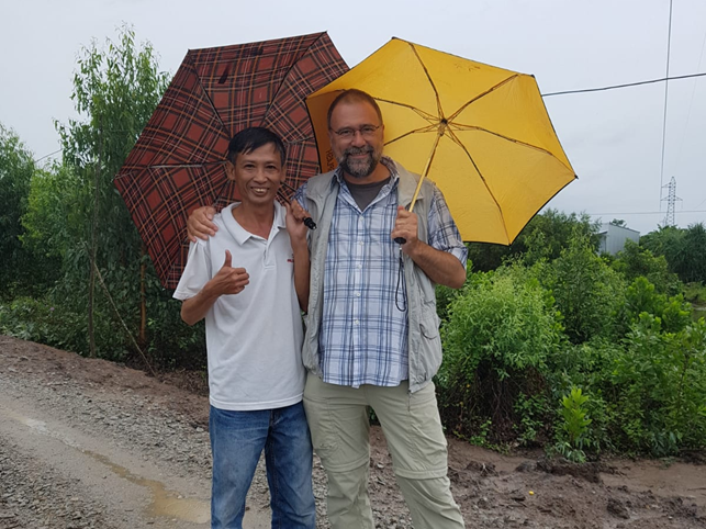 Dr. Duong Van Nha und Prof. Dr. Folkard Asch im Regen während einer Feldbesichtigung.

