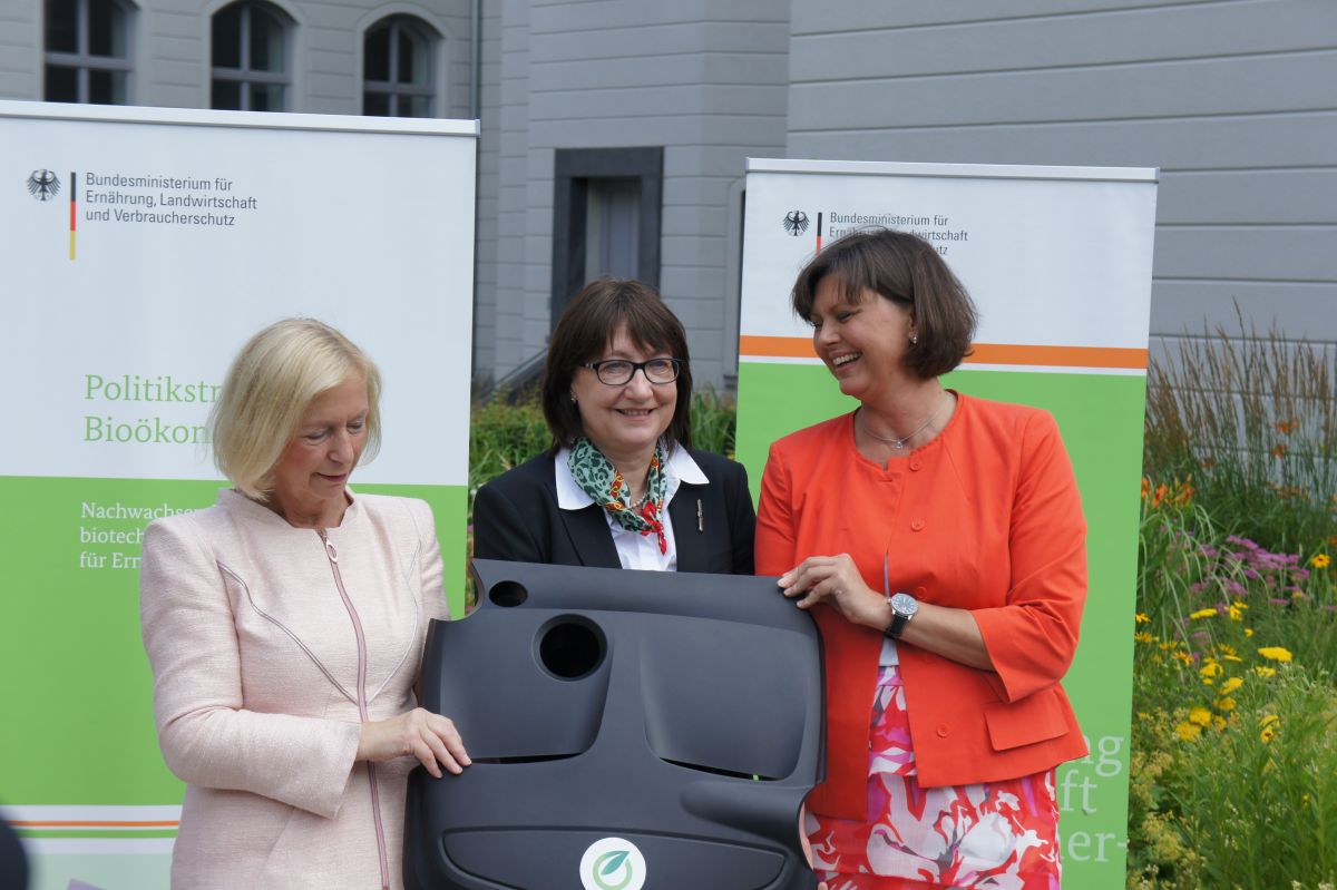 Bioplastik in der Autoindustrie. Die Bundesministerinnen Ilse Aigner (rechts) und Prof. Dr. Johanna Wanka (links) präsentieren mit Prof. Dr. Christine Lang, Vorsitzende des Bioökonomierats (mitte), eine Motorabdeckung aus Biopolyamid.

